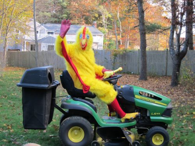 Person in chicken costume on a lawn tractor